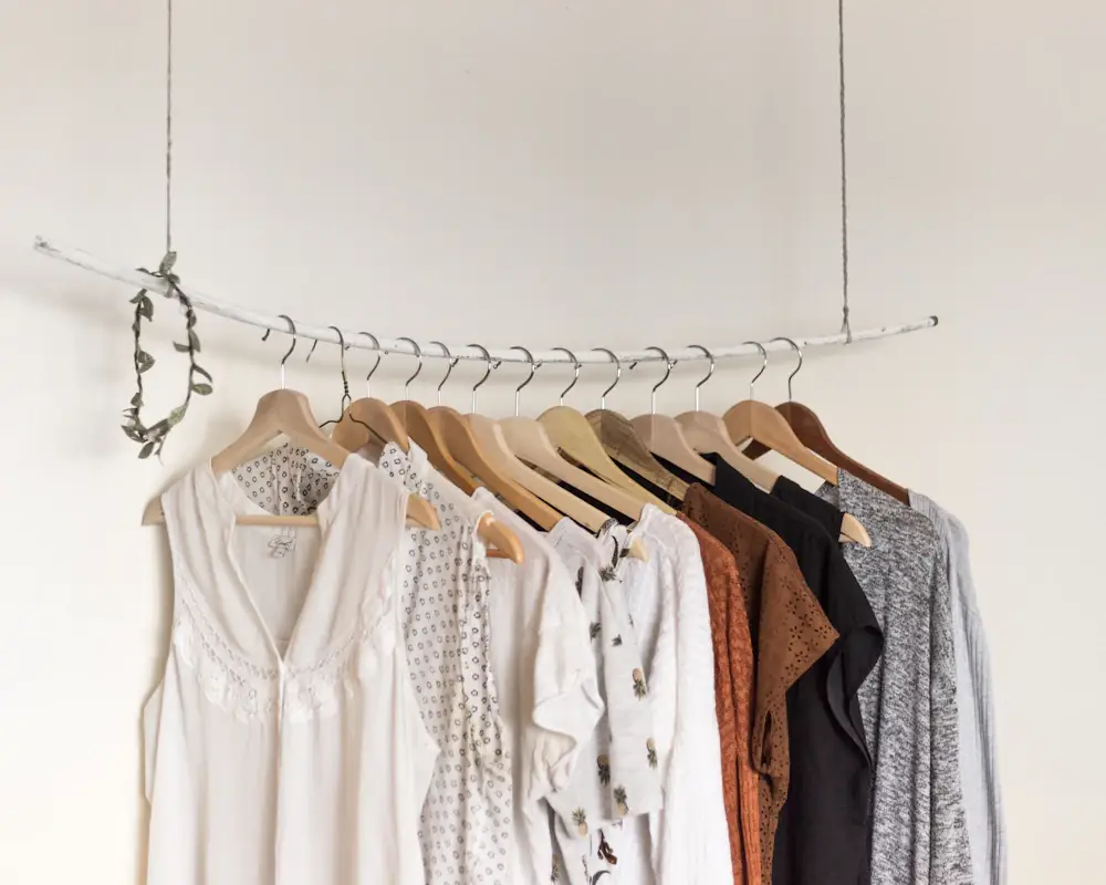 Neutral shirts and knits on wooden hangers