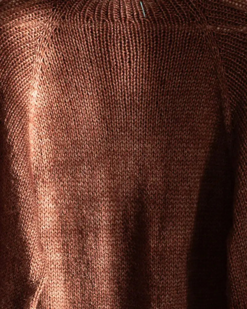 Brown rib knit jumper on a white hanger, close-up