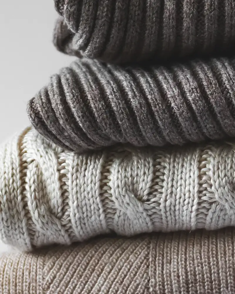 Stack of folded merino jumpers, close-up