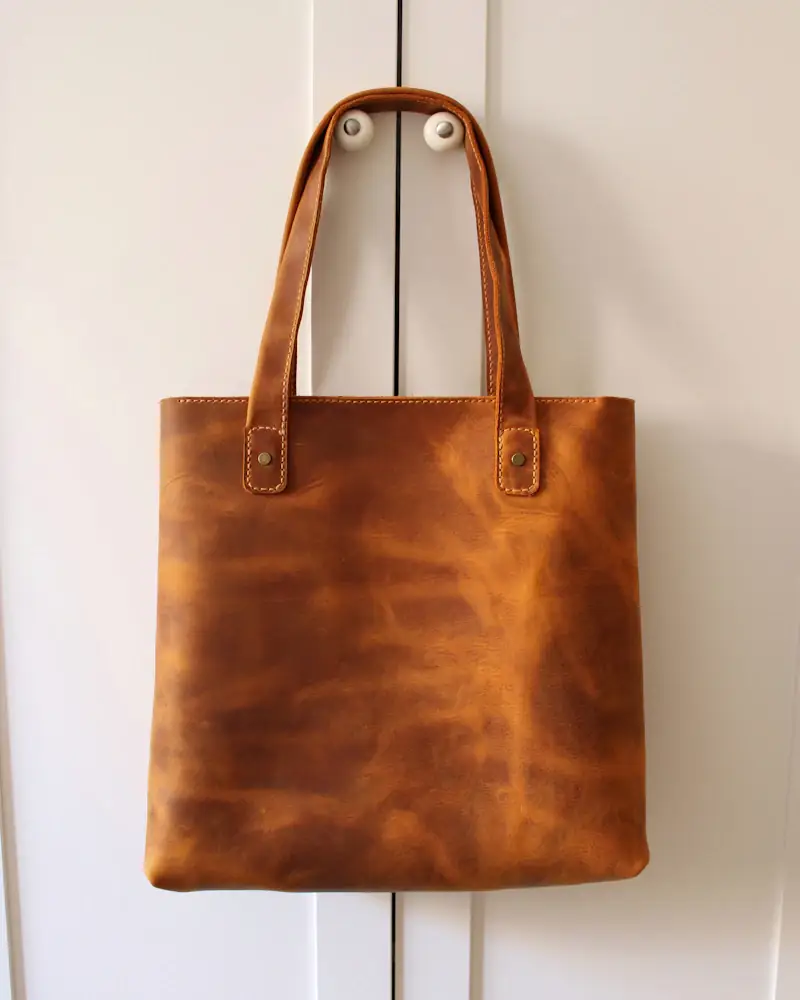Cognac leather tote hanging on a door