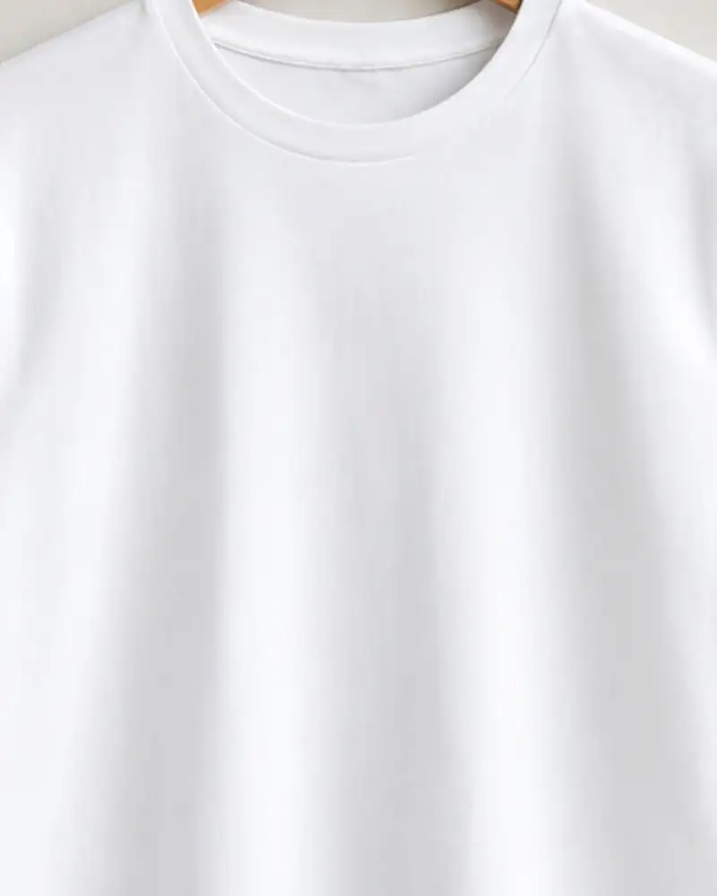 White cotton t-shirt on a wooden hanger, close-up
