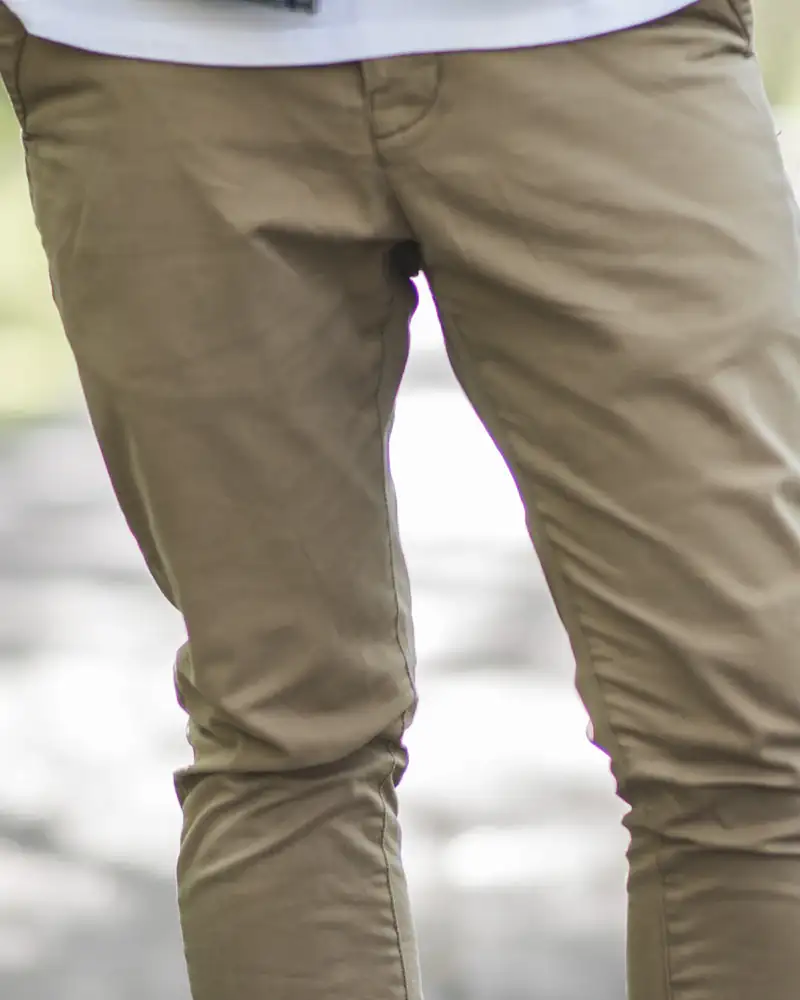 Khaki chinos worn with white trainers, close-up