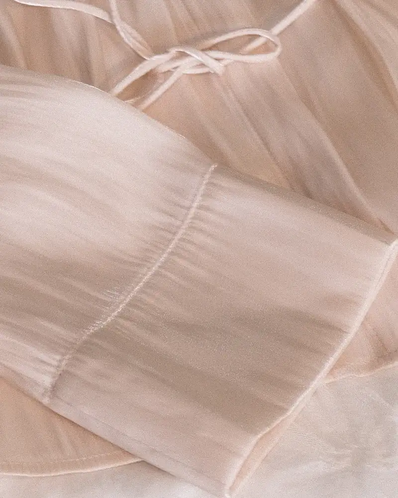 Shell pink satin blouse with a tie waist, close-up
