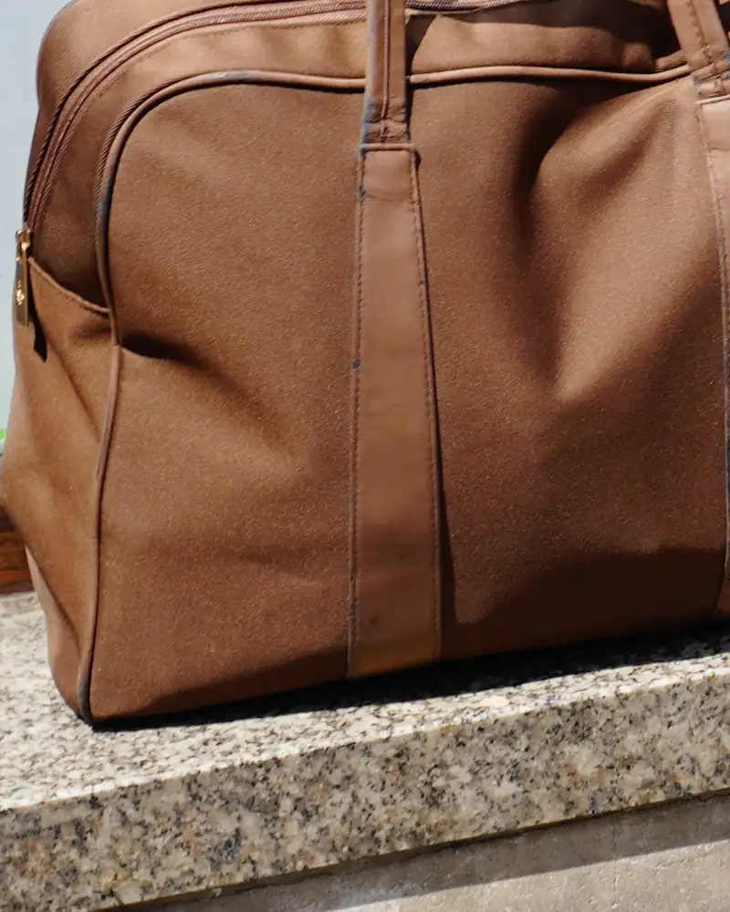 Saddle leather weekend bag on stone steps, close-up
